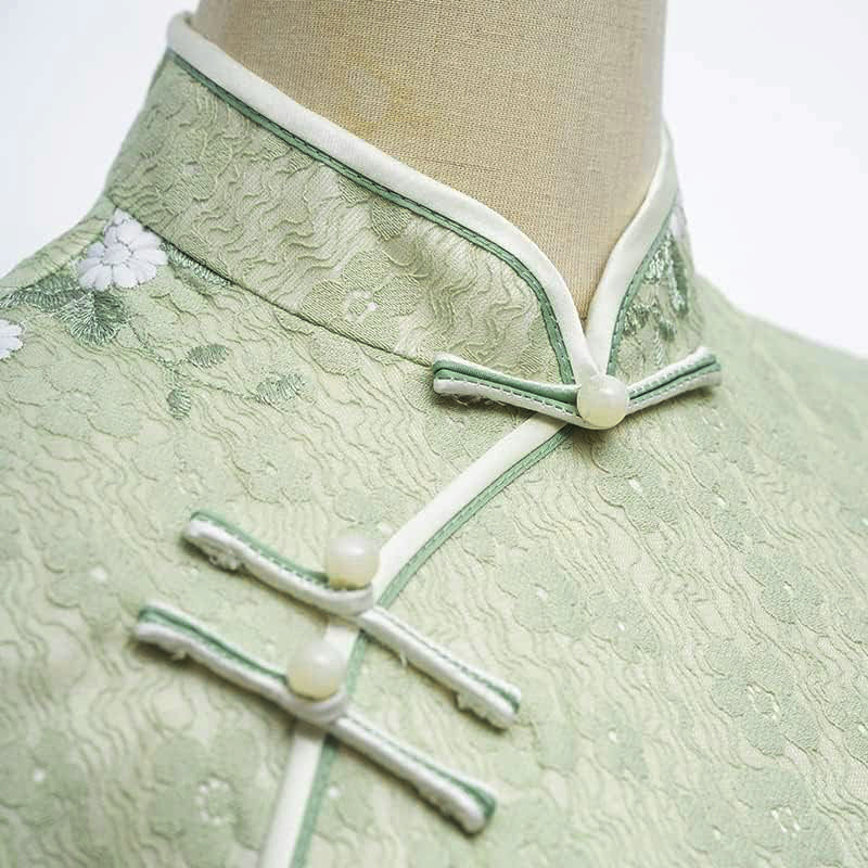 Woman wearing a pastel green modern Cheongsam dress with floral lace embroidery,
