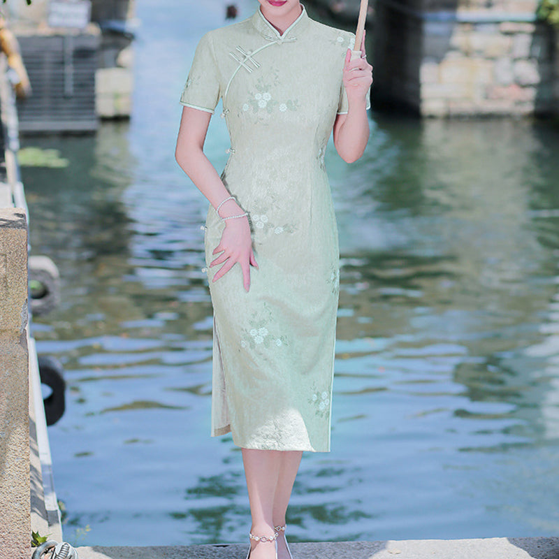 Woman wearing a pastel green modern Cheongsam dress with floral lace embroidery,