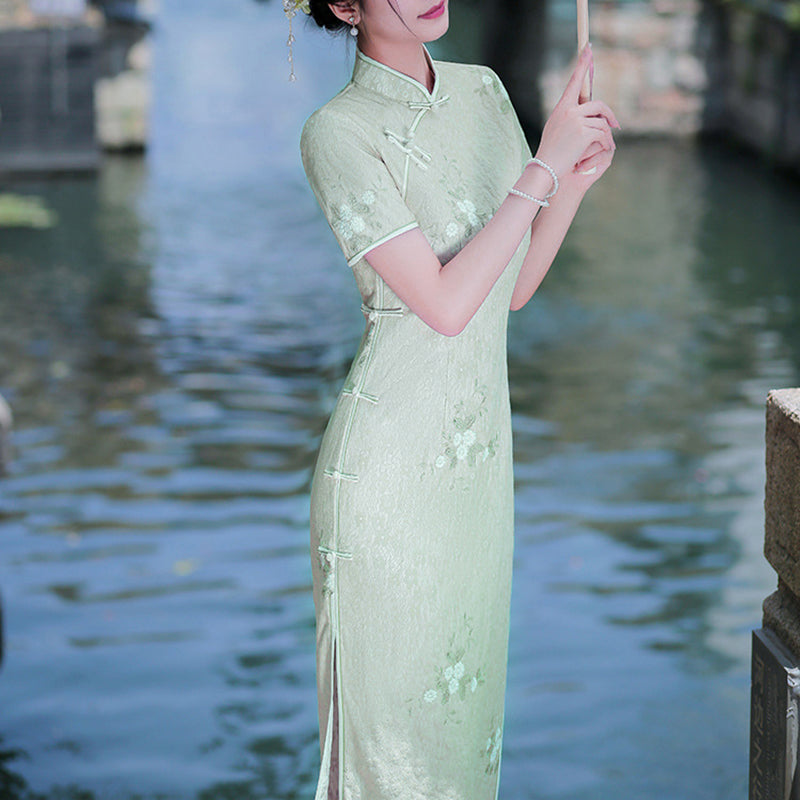 Woman wearing a pastel green modern Cheongsam dress with floral lace embroidery,