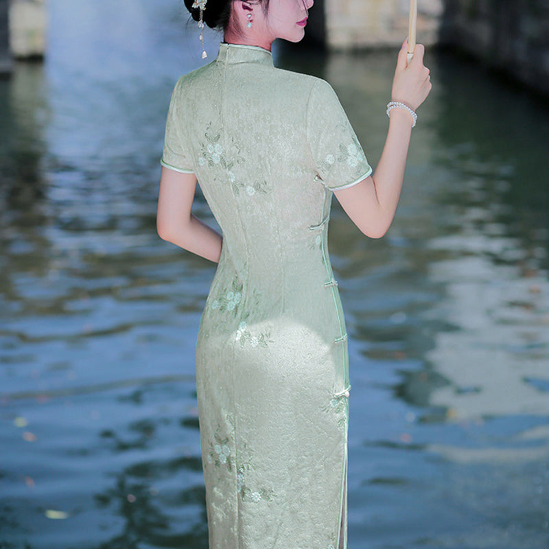 Woman wearing a pastel green modern Cheongsam dress with floral lace embroidery,
