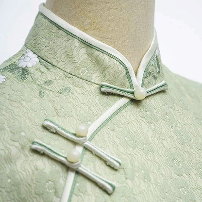 Woman wearing a pastel green modern Cheongsam dress with floral lace embroidery, 