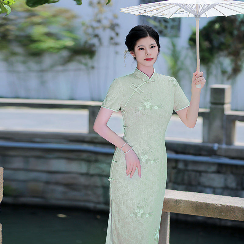 Woman wearing a pastel green modern Cheongsam dress with floral lace embroidery, 