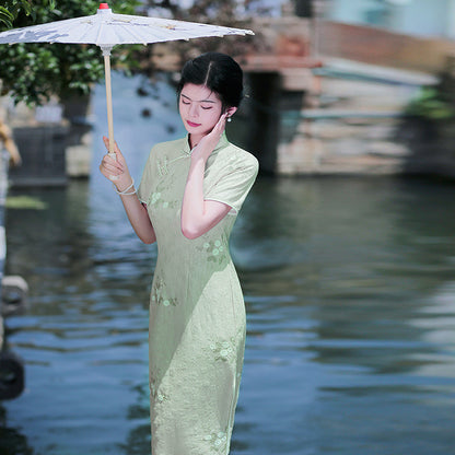 Woman wearing a pastel green modern Cheongsam dress with floral lace embroidery, 